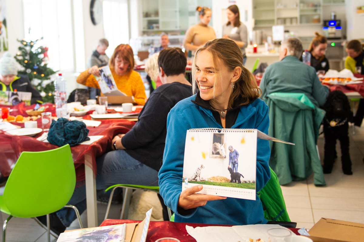 Junghundetrainerin zeigt den Kalender der Blindenhundeschule Liestal.