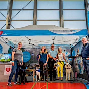Das Team hat alles aufgestellt und steht vor Zelt und Flaggen parat.